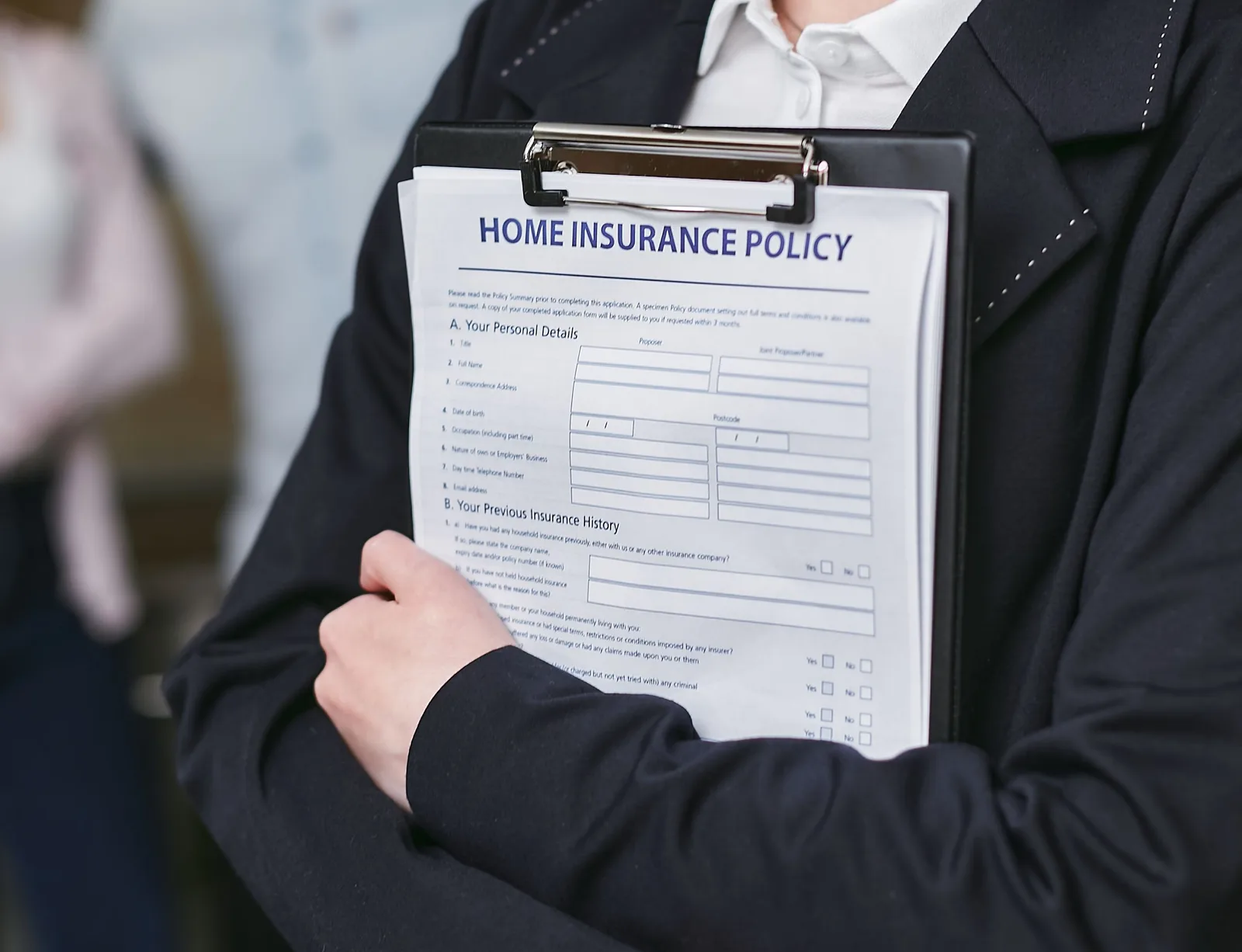 Close-up of a person holding a home insurance policy on a clipboard, captured indoors. Janitorial Facility Contract Insurance Requirements: What US Clients Ask For